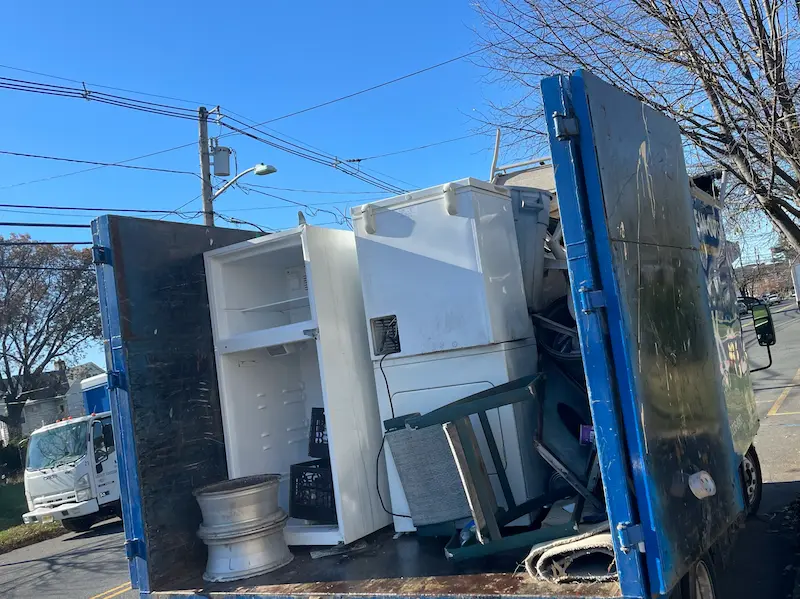 Junk Doctors NJ truck loaded with a variety of old household appliances, including refrigerators and washing machines, ready for recycling.