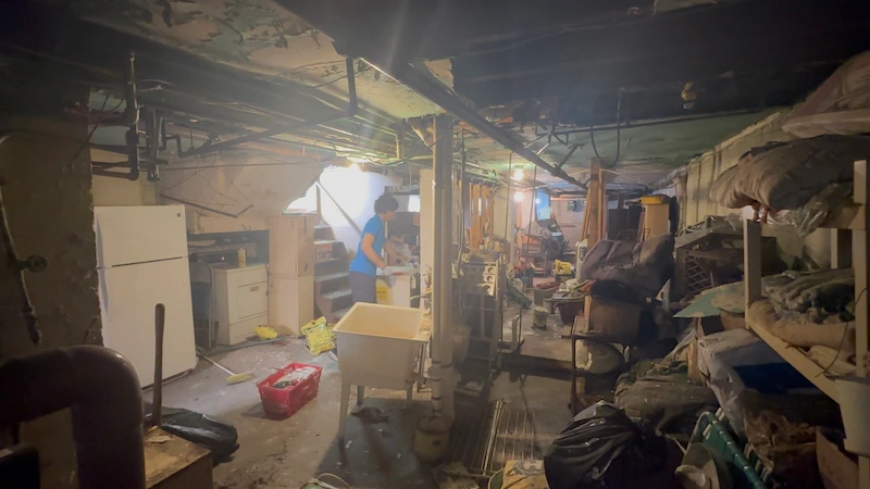 Professional basement cleanout in a water-damaged North NJ home, featuring the removal of wet appliances, shelving, and household debris.