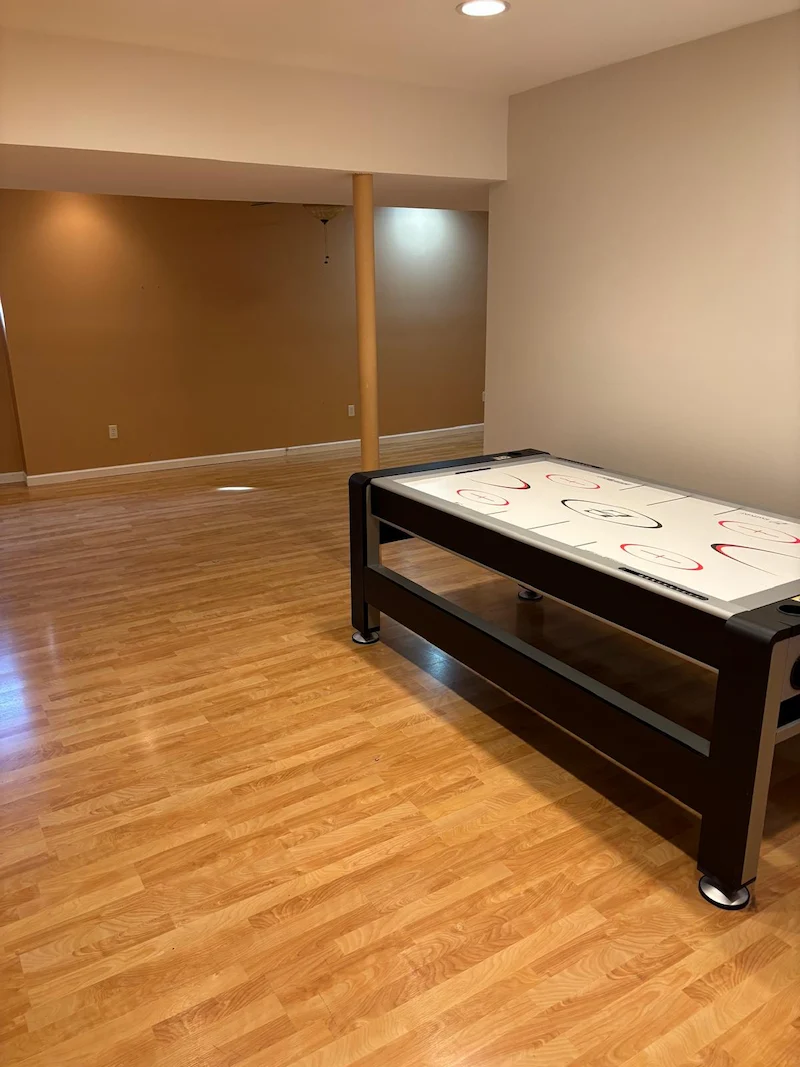 A wide-open, cleared basement floor in Randolph, North Jersey after Junk Doctors removed storage bins and unwanted furniture.