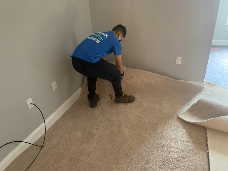 A JunkDoctors team member professionally ripping up and removing old carpet during a residential cleanout in New Jersey.