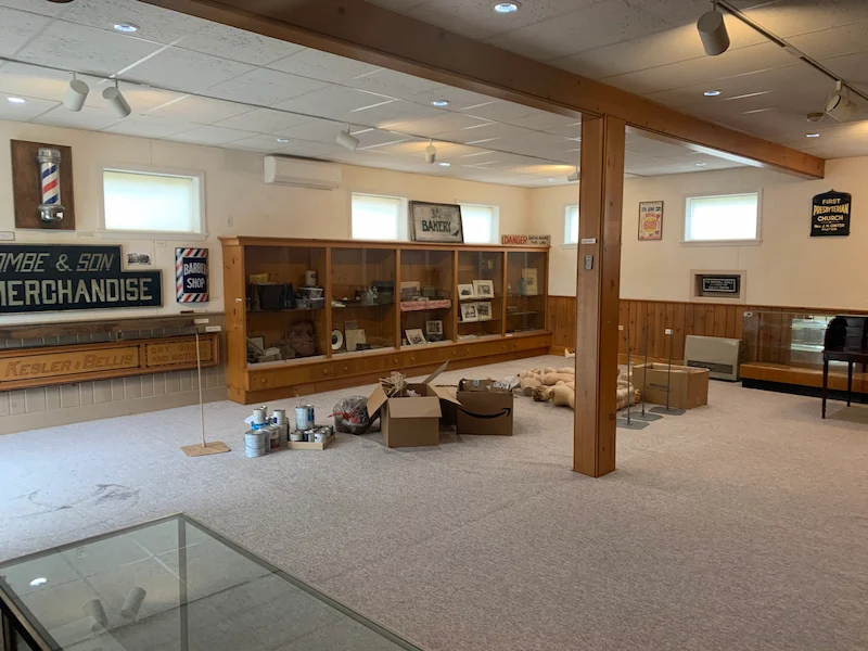 A library basement space with old, worn carpet before removal by JunkDoctors in North Jersey.