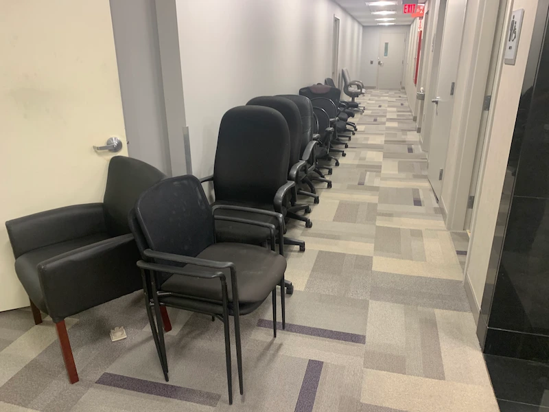A long row of office chairs in a hallway before a commercial office cleanout in New Jersey by JunkDoctors.