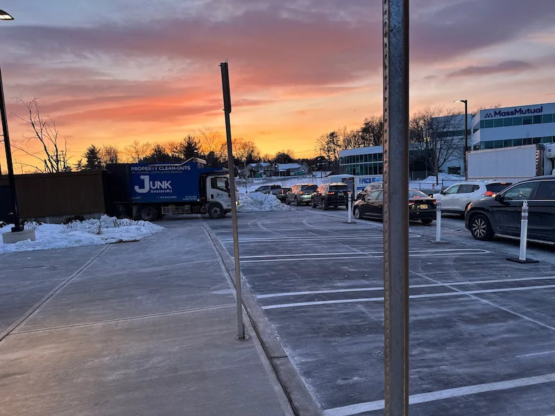 A Junk Doctors NJ truck on-site at a corporate office complex in North NJ during sunset, providing professional office cleanout and commercial junk removal services.