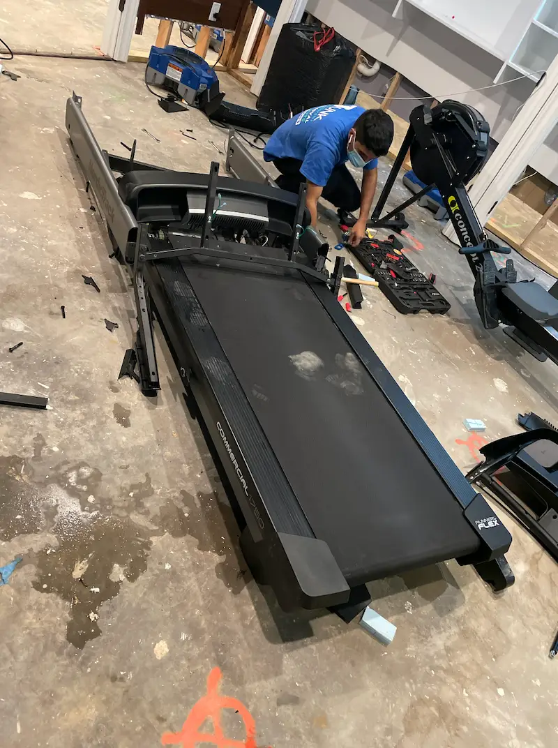 Dismantling a treadmill during a basement cleanout in New Jersey
