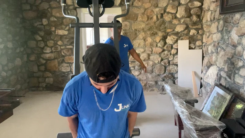 Professional removal of an elliptical machine from a basement gym during a residential cleanout in North NJ.