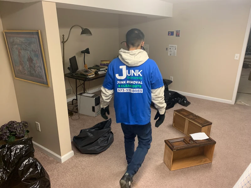 JunkDoctors crew member removing a desk, drawers, and electronics from a finished basement in New Jersey.