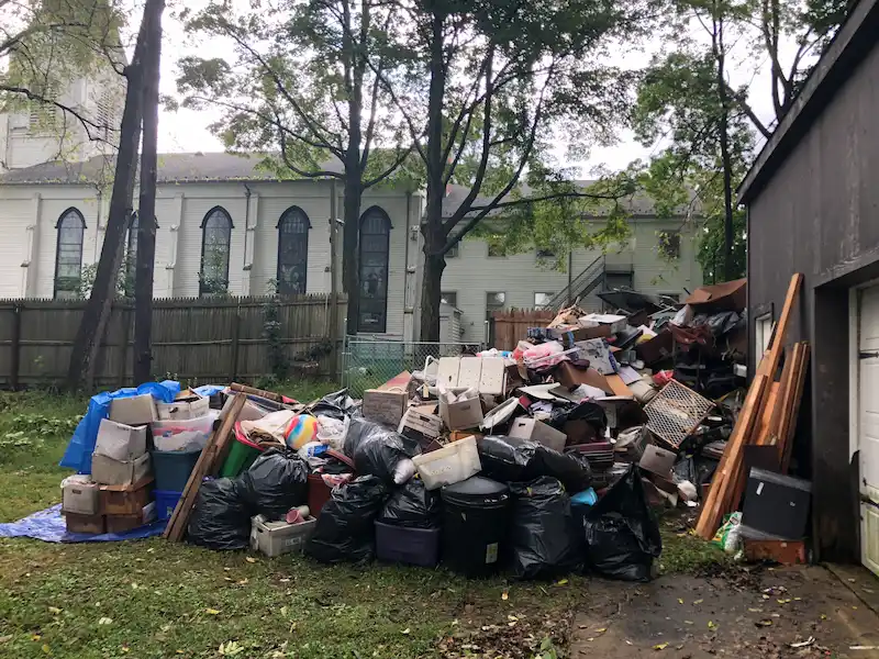 A large pile of debris, boxes, and household items from a basement flood waiting for an emergency water damage cleanout in NJ.