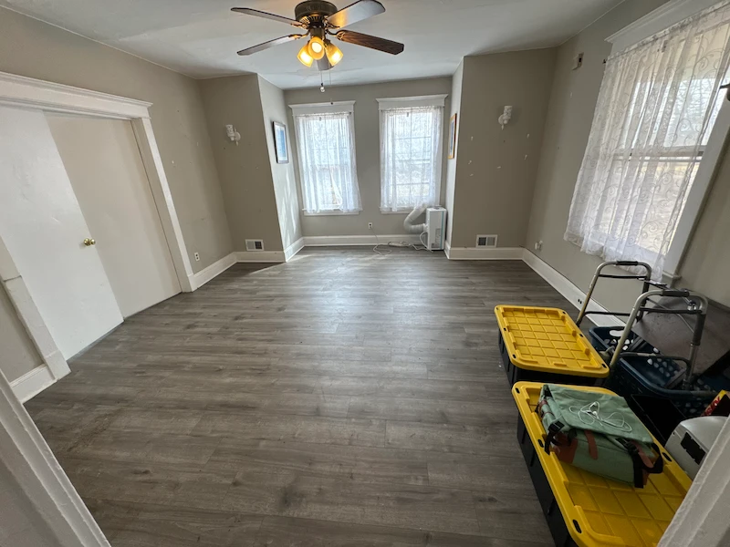 The same living room after all junk, furniture, and clutter have been completely removed, showing a clean, empty space.