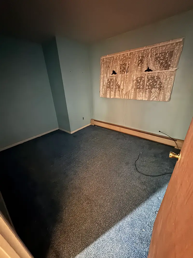 After photo of the same room with all household junk and debris removed, leaving a completely cleared space.