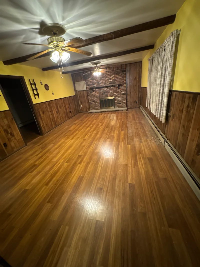 The same North NJ living room completely cleared of all furniture and household junk, showing a bare floor and empty space after service by Junk Doctors NJ.