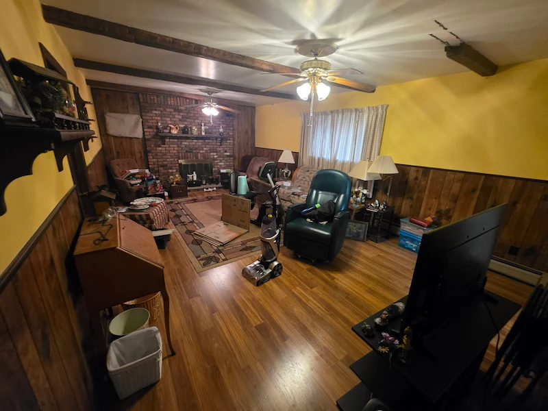Professional household junk removal in North NJ showing a cluttered living room with furniture and electronics before being cleared by JunkDoctors NJ.