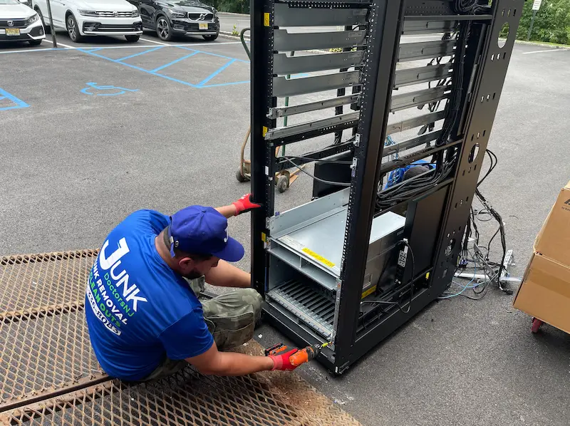 Professional e-waste removal service in NJ showing JunkDoctors team dismantling server equipment for proper recycling.