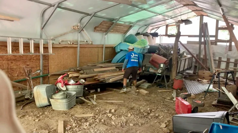 Junk Doctors crew member clearing out debris and old equipment from a large storage shed in North New Jersey.