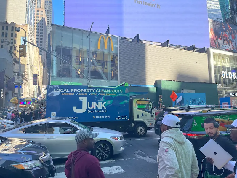 JunkDoctors truck operating on a busy New Jersey roadway during a property cleanout job.