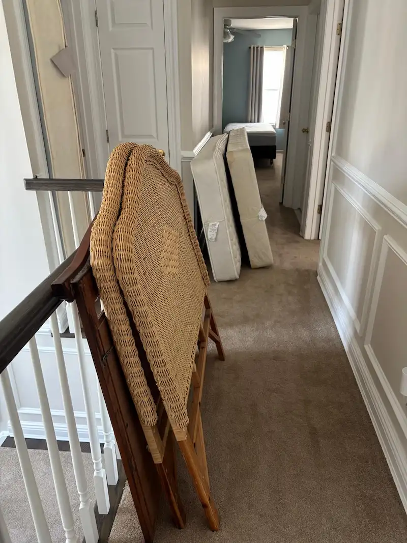 Old mattresses and a wicker headboard lined up in a Madison, North Jersey hallway before being hauled away for disposal.
