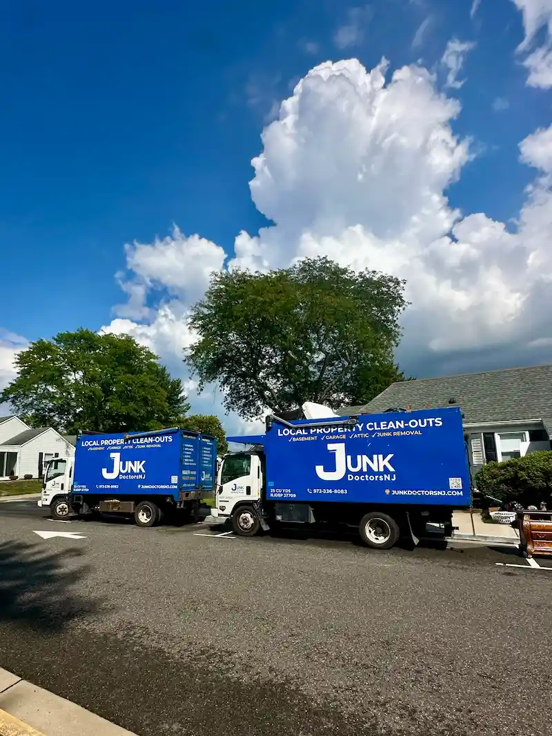 Junk Doctors NJ professional junk removal trucks parked on a residential street for a large mattress removal and property cleanout project.