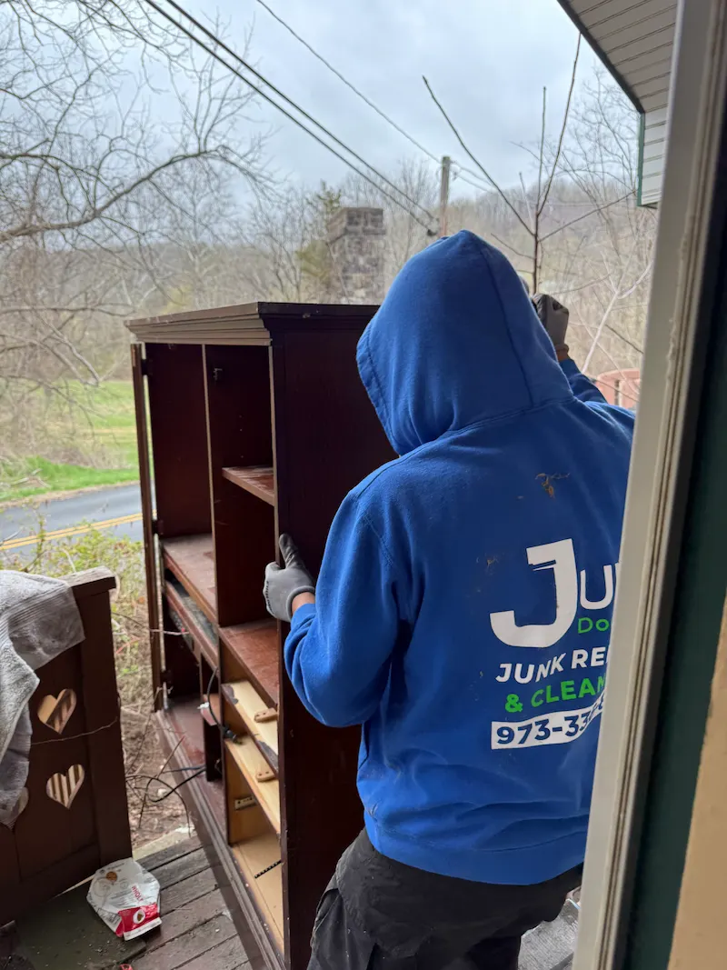 JunkDoctors crew removing a heavy wooden cabinet during a bulky furniture disposal and junk removal job in New Jersey.