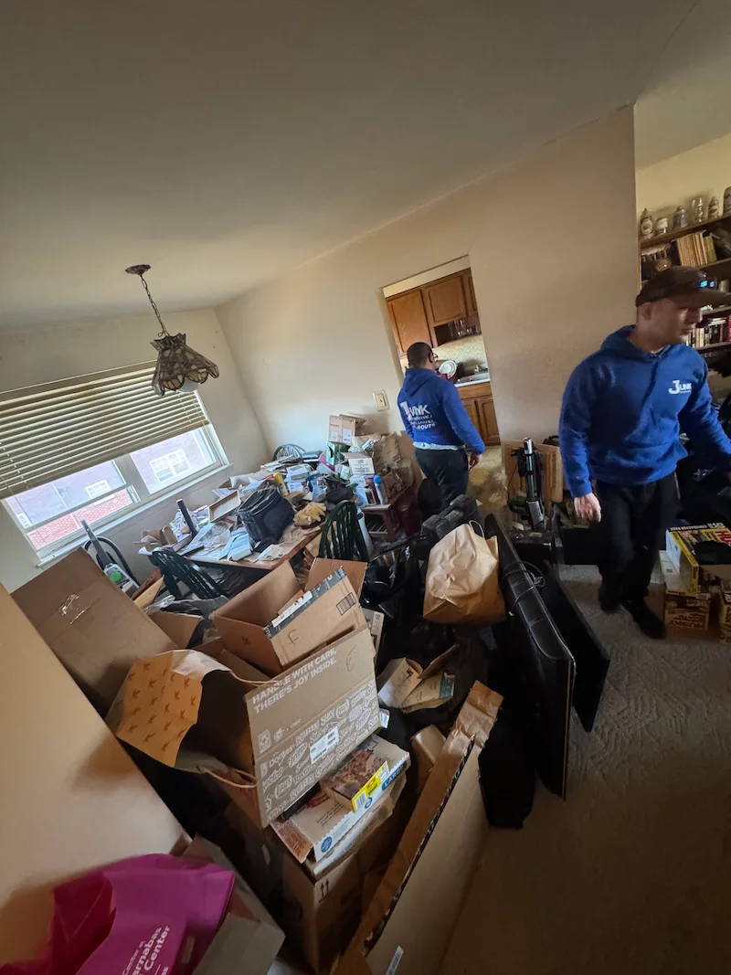 A Hoboken, New Jersey room overwhelmed with boxes and accumulated clutter before a JunkDoctors haul-away.