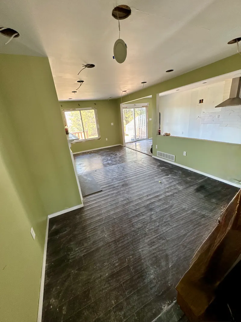 After image showing a living area with all renovation waste removed and the site cleared, leaving a bare floor ready for the next project.