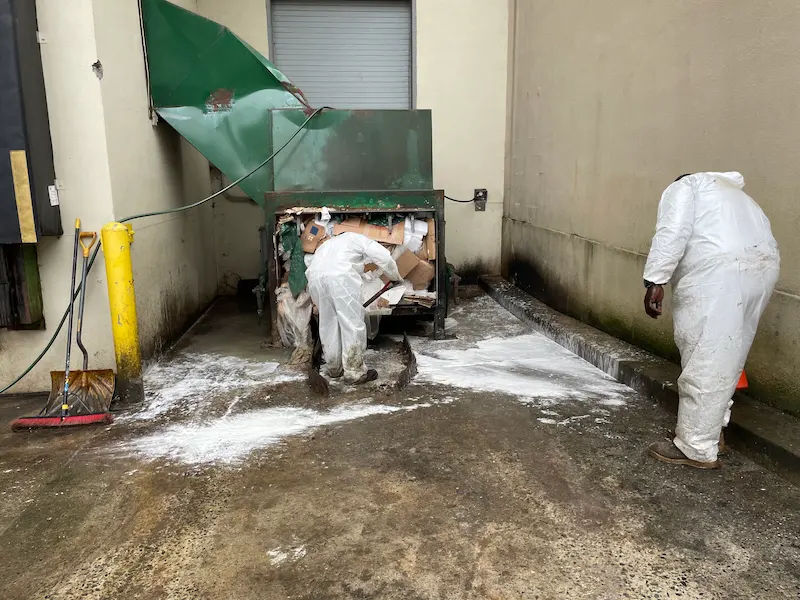 JunkDoctors NJ team in protective suits performing a professional restaurant dumpster and compactor area cleanout in North Jersey.