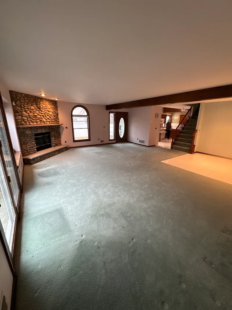 Spacious living room completely cleared of furniture and debris, showing a clean, empty space ready for sale or renovation.