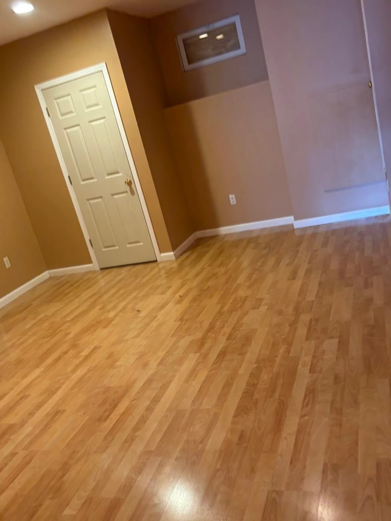 An empty finished basement room after JunkDoctors hauled away a heavy treadmill in New Jersey.
