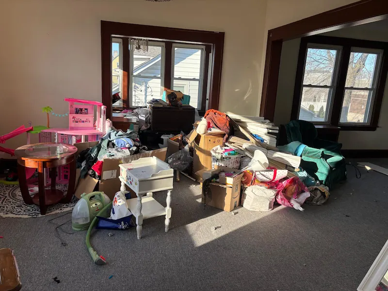 A Sparta, New Jersey living room filled with miscellaneous household junk, boxes, and toys before being hauled away by Junk Doctors.