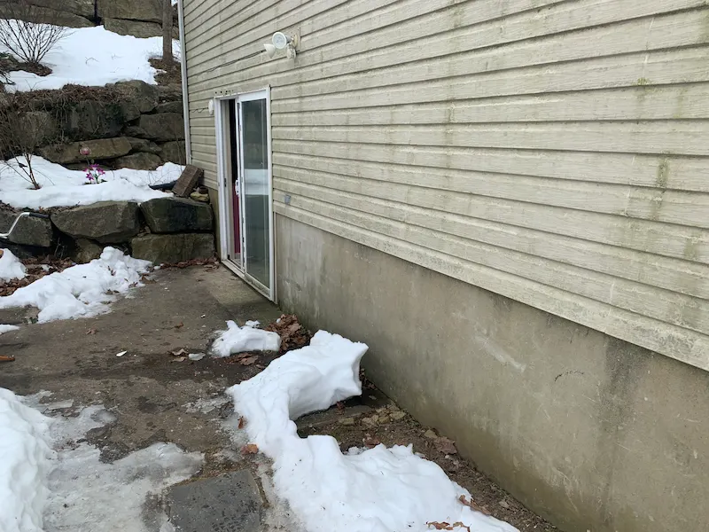 The same snowy patio from the previous image, now completely cleared of all trash bags, chairs, and debris after a Junk Doctors NJ winter yard cleanup.