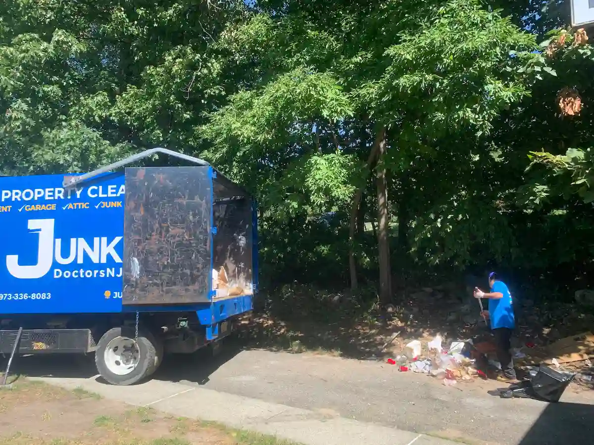 Crew member loading backyard debris into a junk truck.
