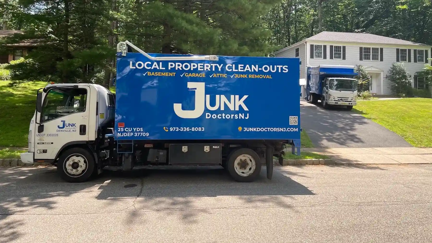 Two JunkDoctors 25-cubic-yard trucks on-site for a large estate cleanout in New Jersey.