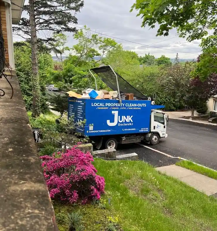 A JunkDoctors truck fully loaded with household items during an estate cleanout on a residential New Jersey street.