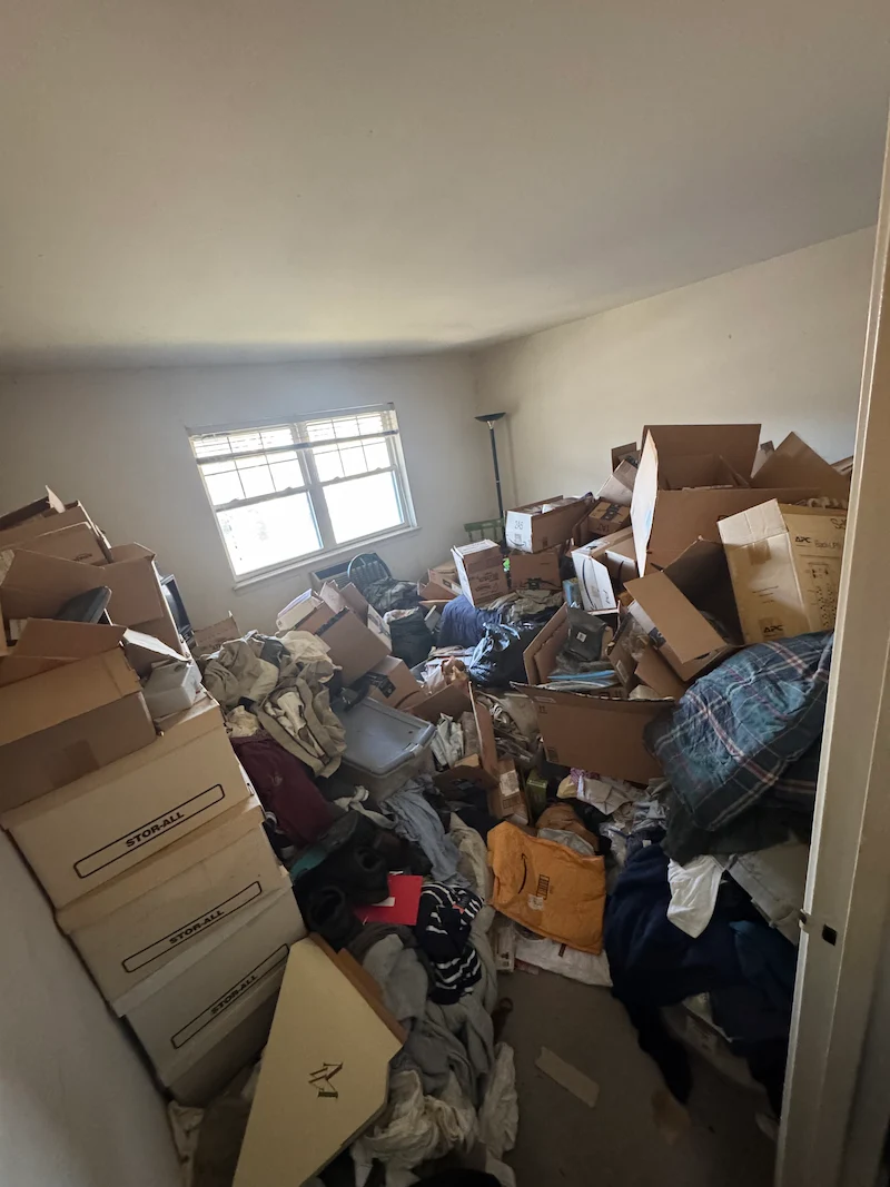 Heavily cluttered room before hoarding cleanup