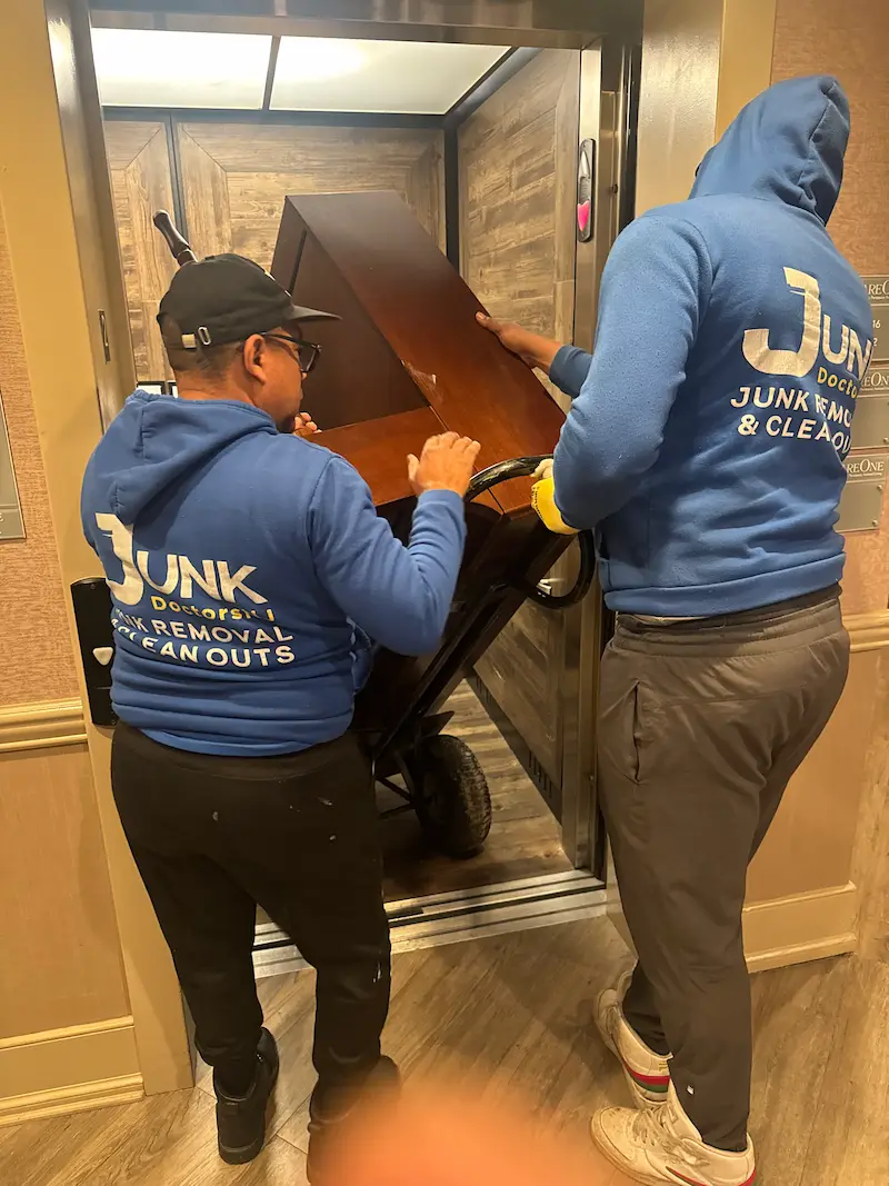 JunkDoctors crew moving a piano during a cleanout.